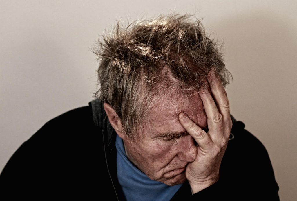 A man holding his head in his hand.